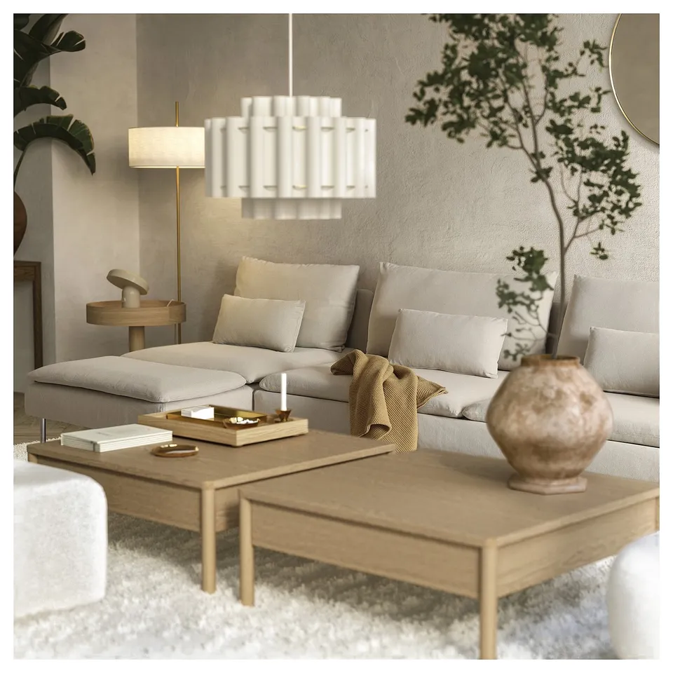 Displays a modern, beige SÖDERHAMN sofa bed in a cosy living room setup, complemented by neutral-colored decor and a stylish chandelier.