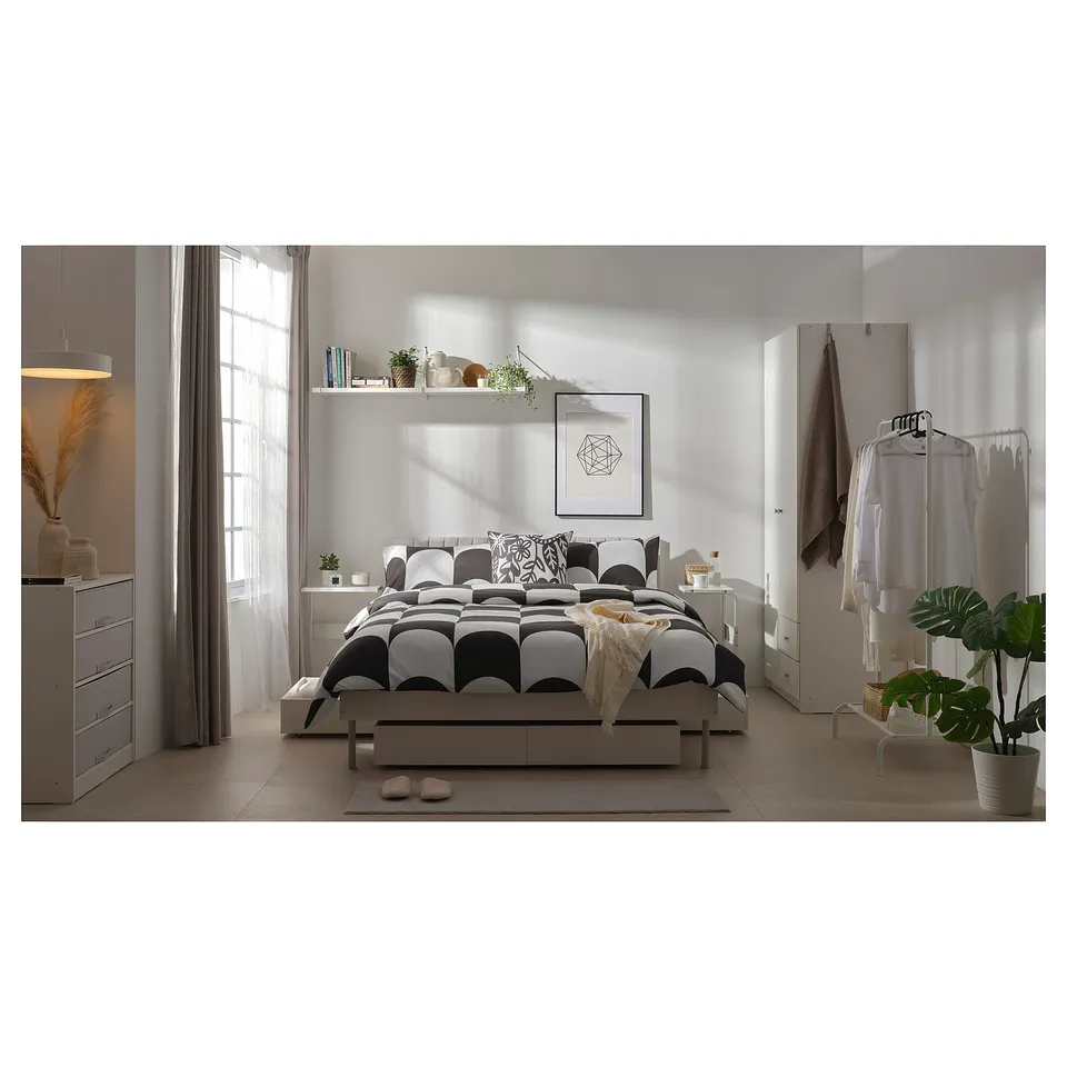 Modern bedroom with BRUKSVARA bed, storage, white wardrobe, plants, minimal decor.