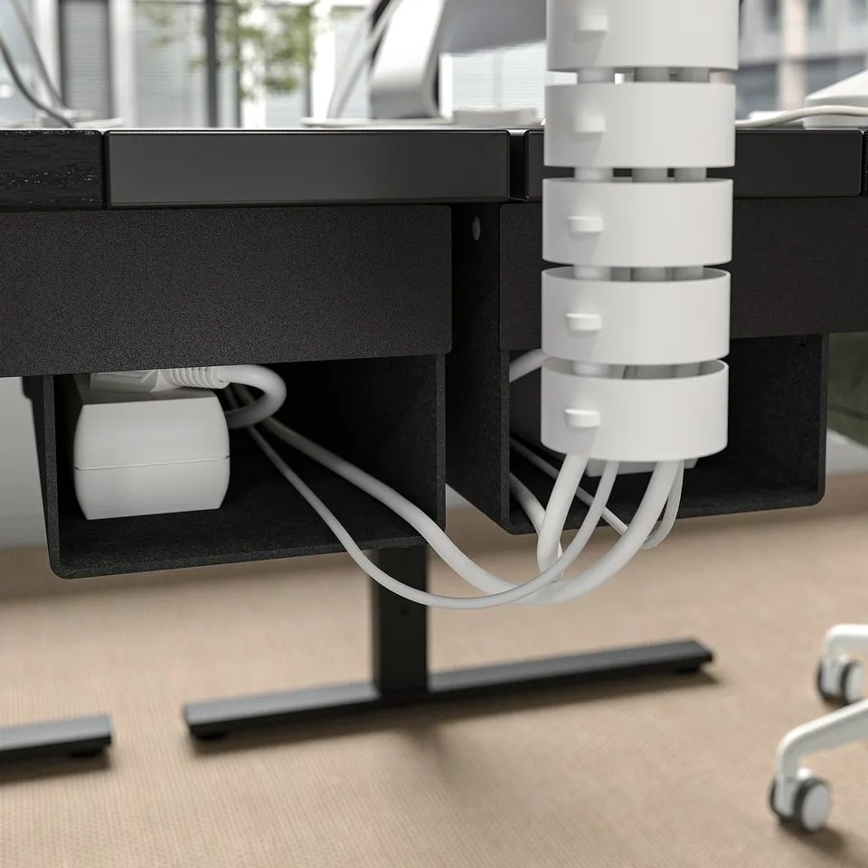 Desks cable management tray with loads of cords organised.