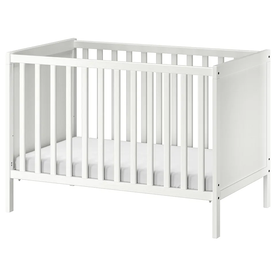 A white SUNDVIK baby cot with vertical bars and a removable side, suitable for an infants comfortable and safe sleep.