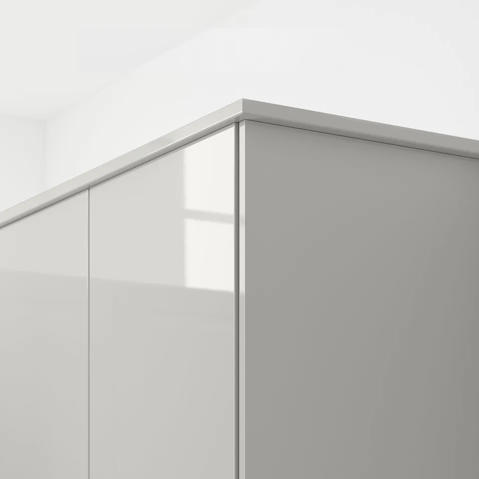Close-up of modern kitchen cabinet edge with glossy grey surface reflecting light, showing its easy-to-clean finish.