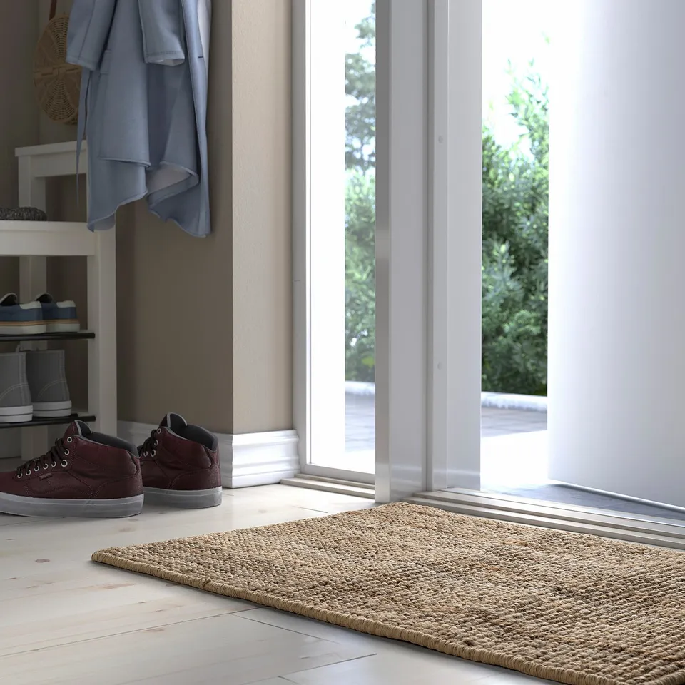Jute door mat near window, small, rustic, decorative & functional.