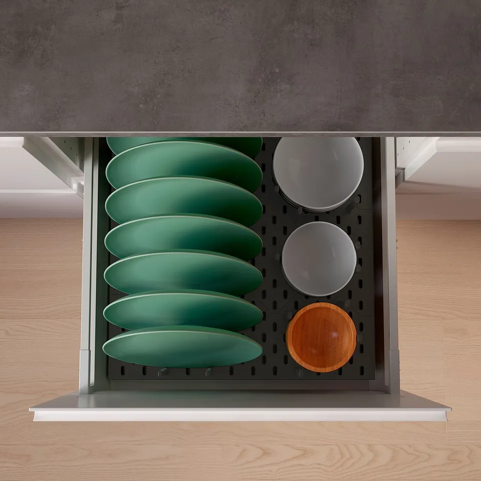 Organised kitchen drawer with green plates and bowls, using updatera pegs for storage.