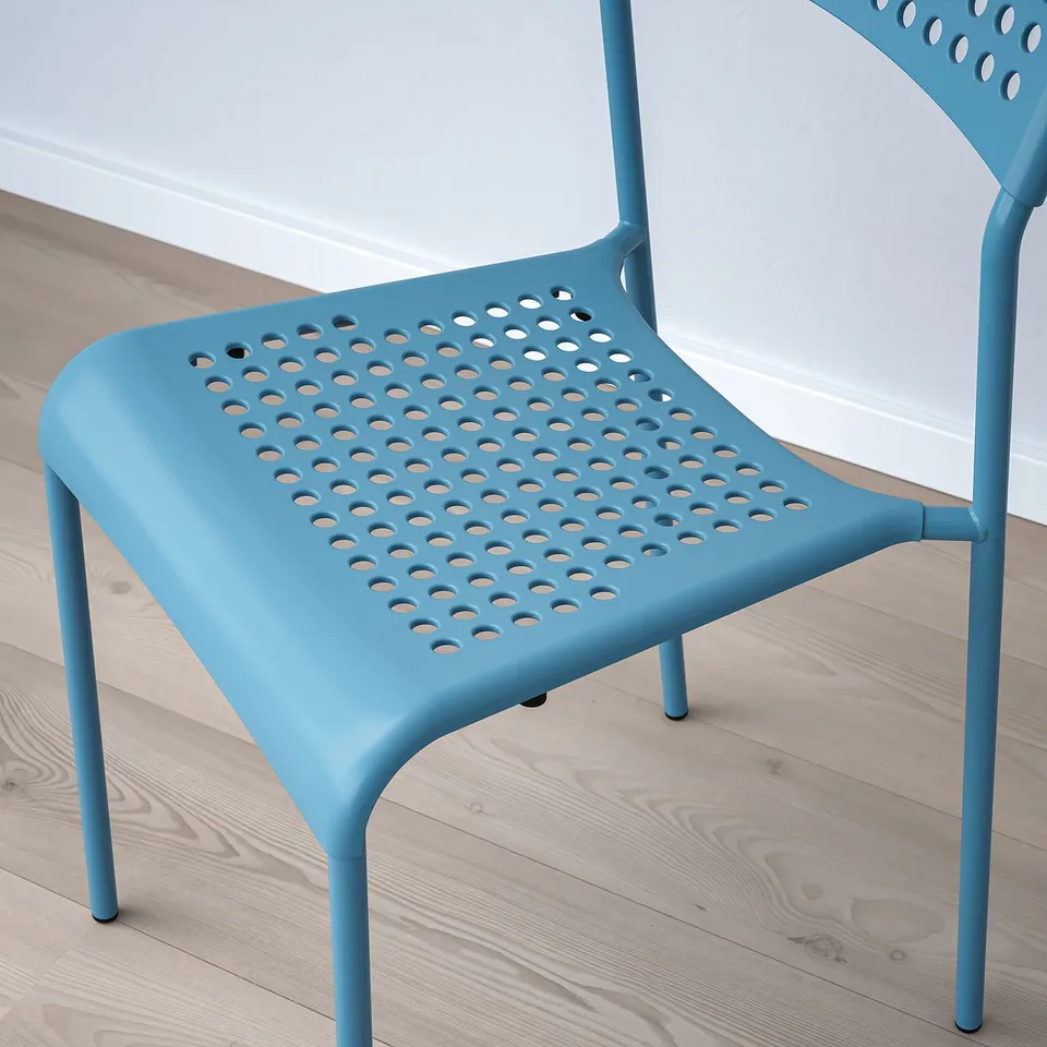 Bright blue modern chair with perforated seat and back, stackable design.