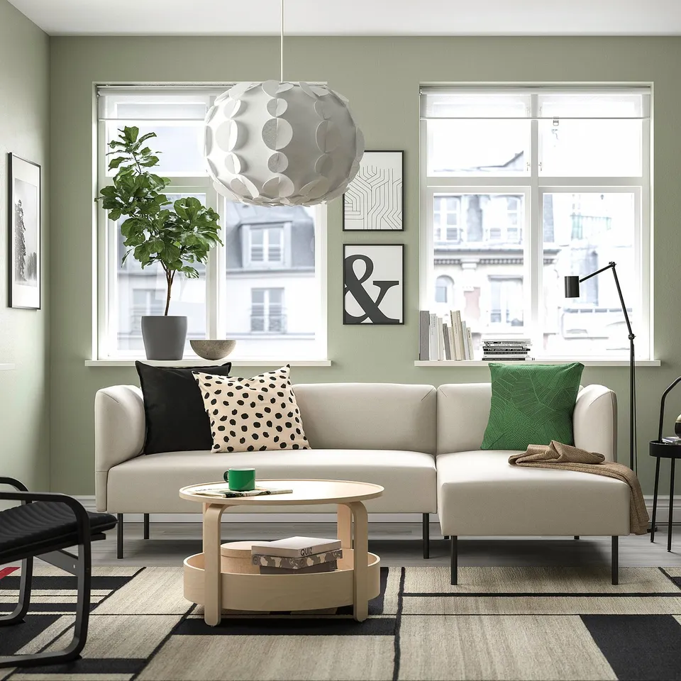 Modern sofa, round light, books, plants, art, urban view, cosy room.