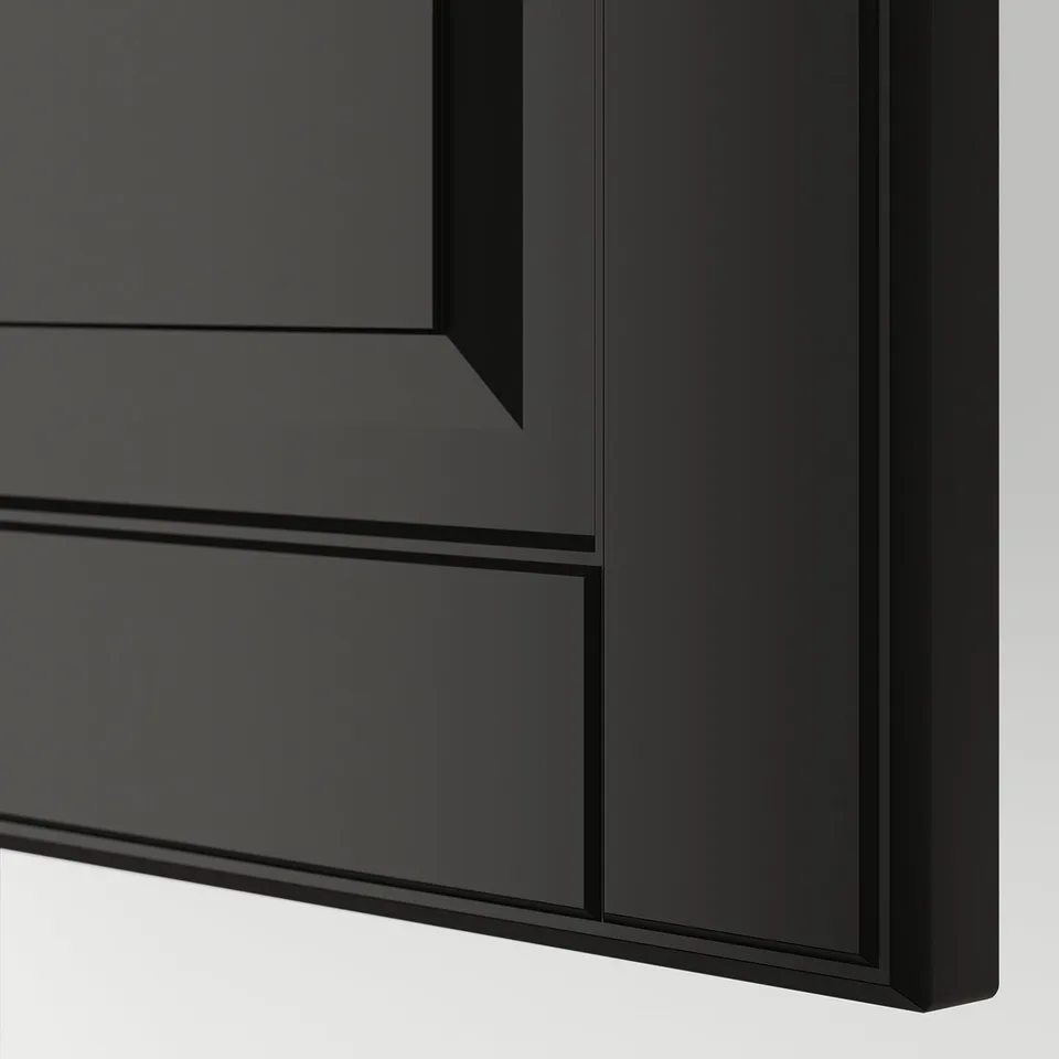 Close-up of sleek, black, modern kitchen cabinet with bevelled edges and smooth finish.