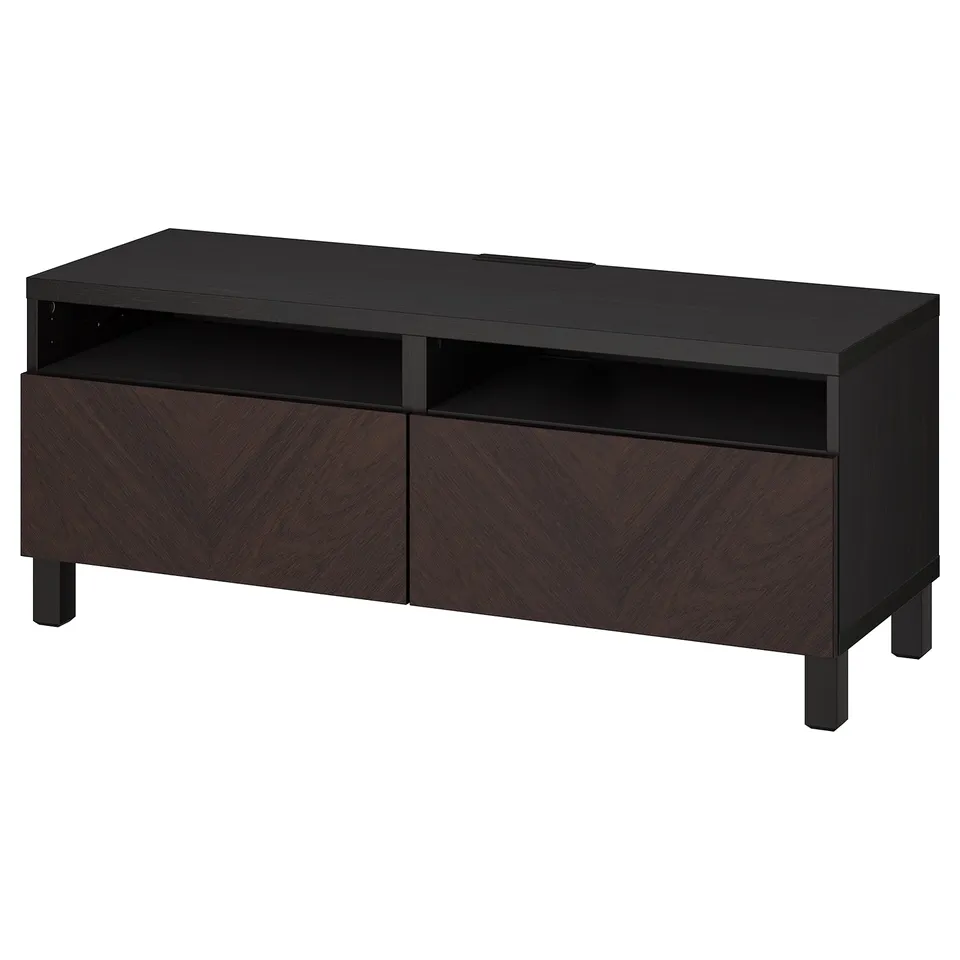 Black BESTÅ tv stand with dark brown chevron-patterned drawers, wooden legs. Sleek, rectangular design with open shelf and cable outlet.