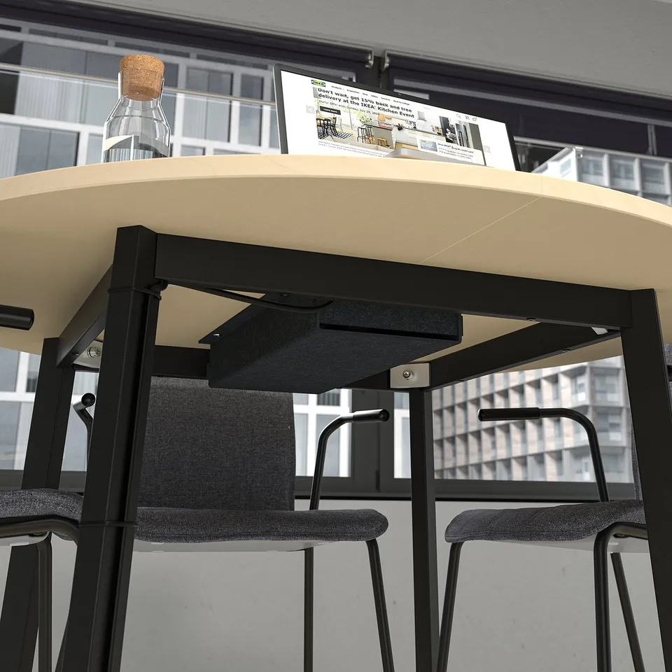 Image a round table with a bottle and instruction manual, demonstrating its use for meetings or workspaces, highlighting space for items under table.