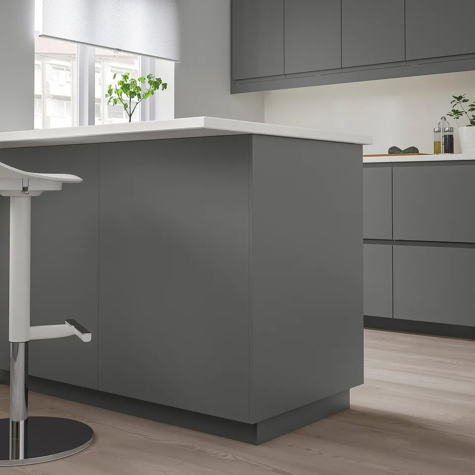 Modern grey FÖRBÄTTRA kitchen island. Sleek cabinets with glossy finish, slim countertop. Tall, rectangular design, larger than stool.