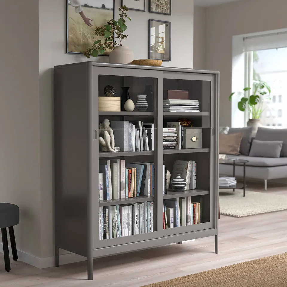 Black IDÅSEN glass cabinet with books & decor, modern design.