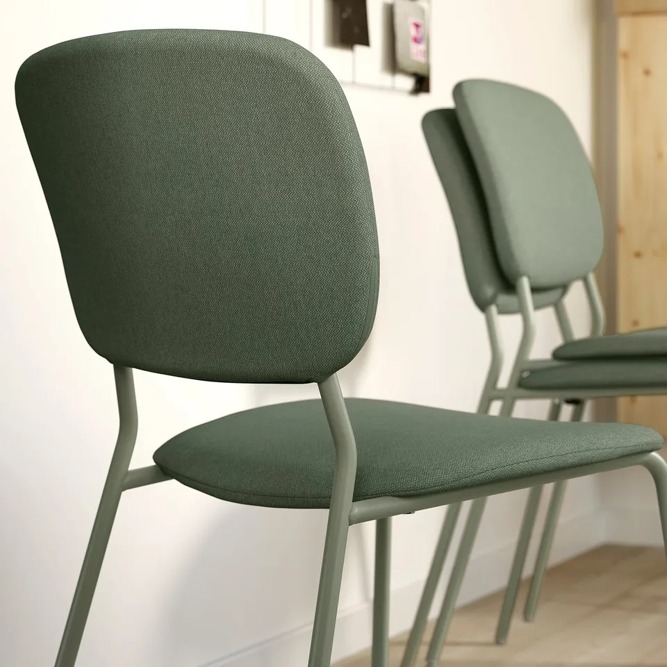 Modern green chairs with metal legs in room.