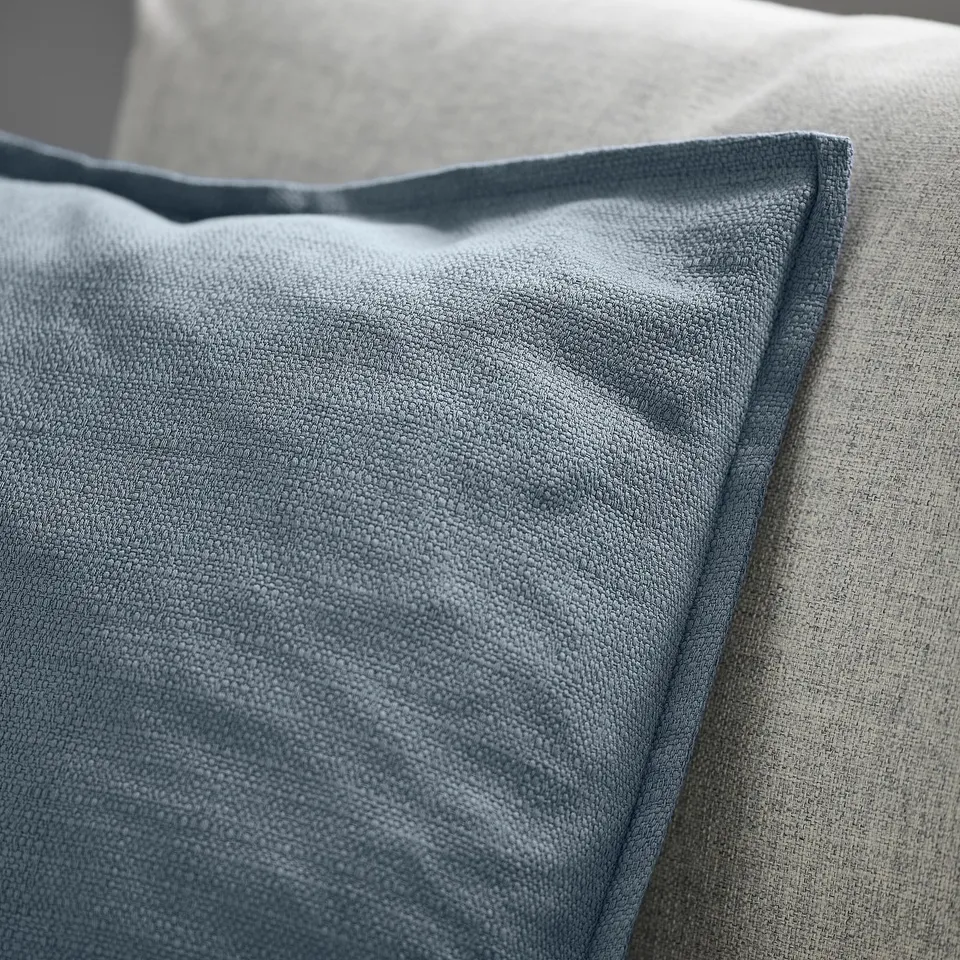 Close-up of LAGERPOPPEL cushion cover, displaying its textured, blue-grey fabric and zip detail.