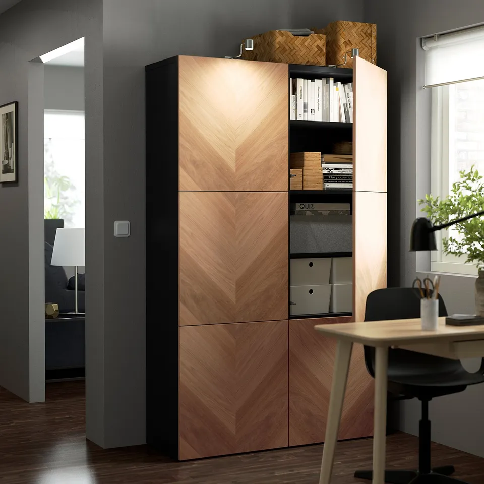 Modern office corner with wooden BESTÅ cabinet, adjustable shelves, and open storage. Desk and chair included.