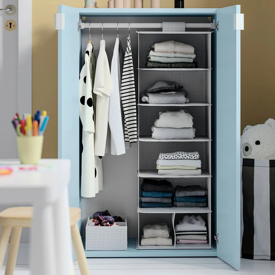 Kids light blue wardrobe with adjustable shelves, folded clothes, hanging garments, and shoe boxes.