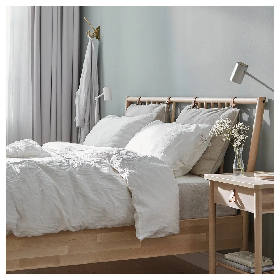 Minimalist bed in natural wood, white linens. Crafted with scandinavian style.