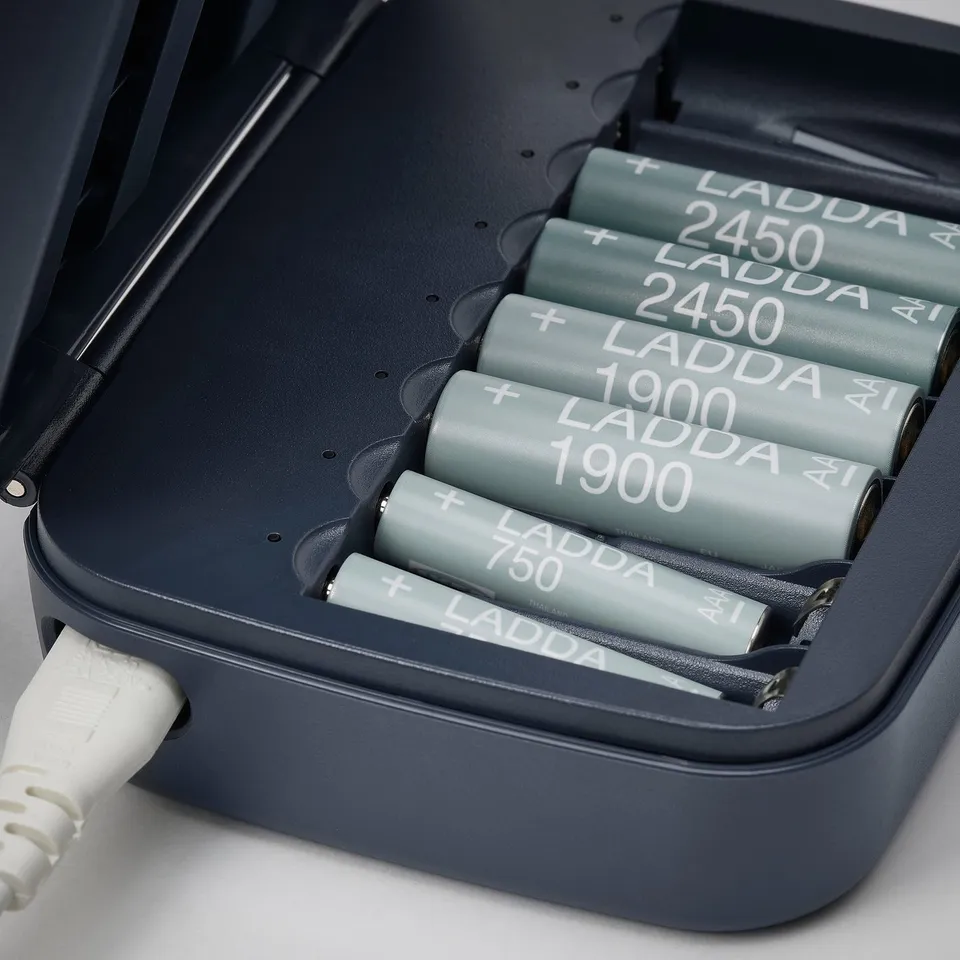 Black charger with 4 grey LADDA batteries and white cable.