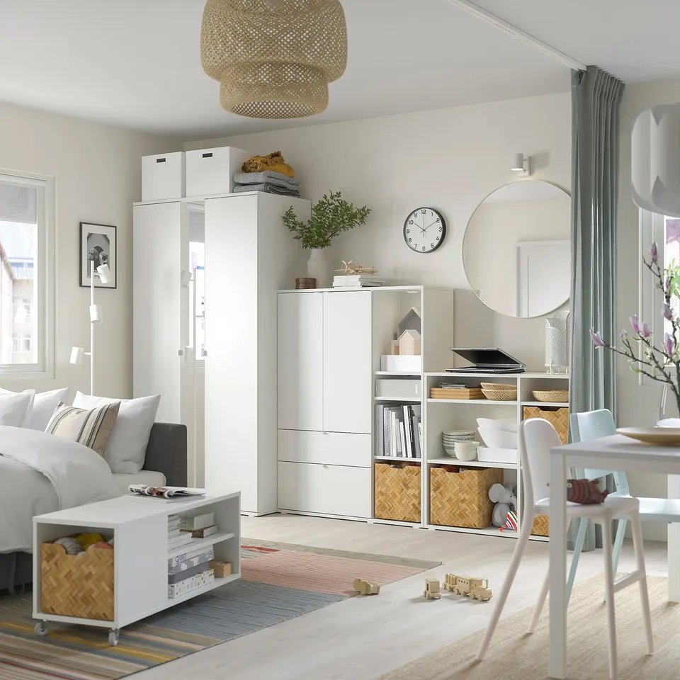 Modern minimalist room with white VIHALS storage. A mirror, shelves, and wicker baskets.
