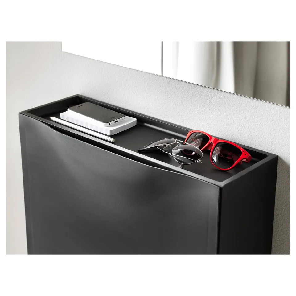 Black TRONES cabinet with small items on top.