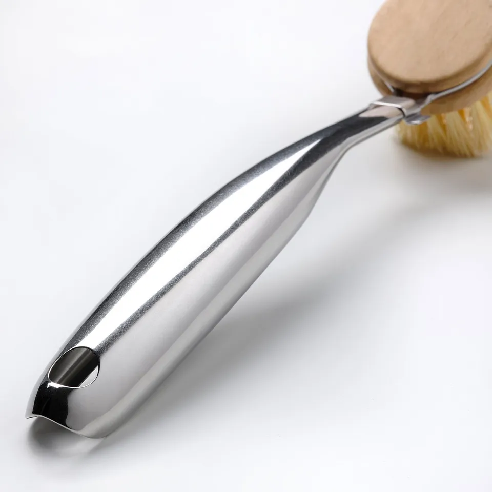 Silver dish brush with wooden handle, stainless steel construction, agave bristles, laid on bright surface.