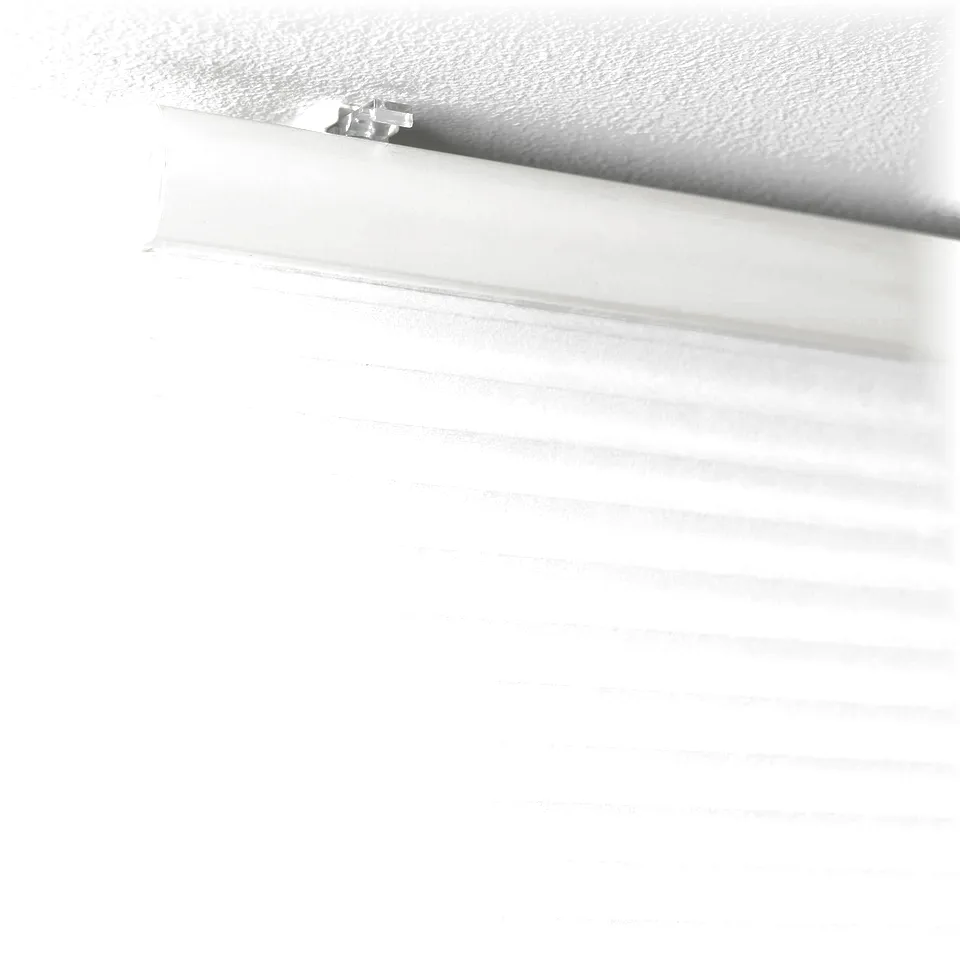 White cellular blind rolled down, mounted on ceiling, showing its light filtering and insulating properties.