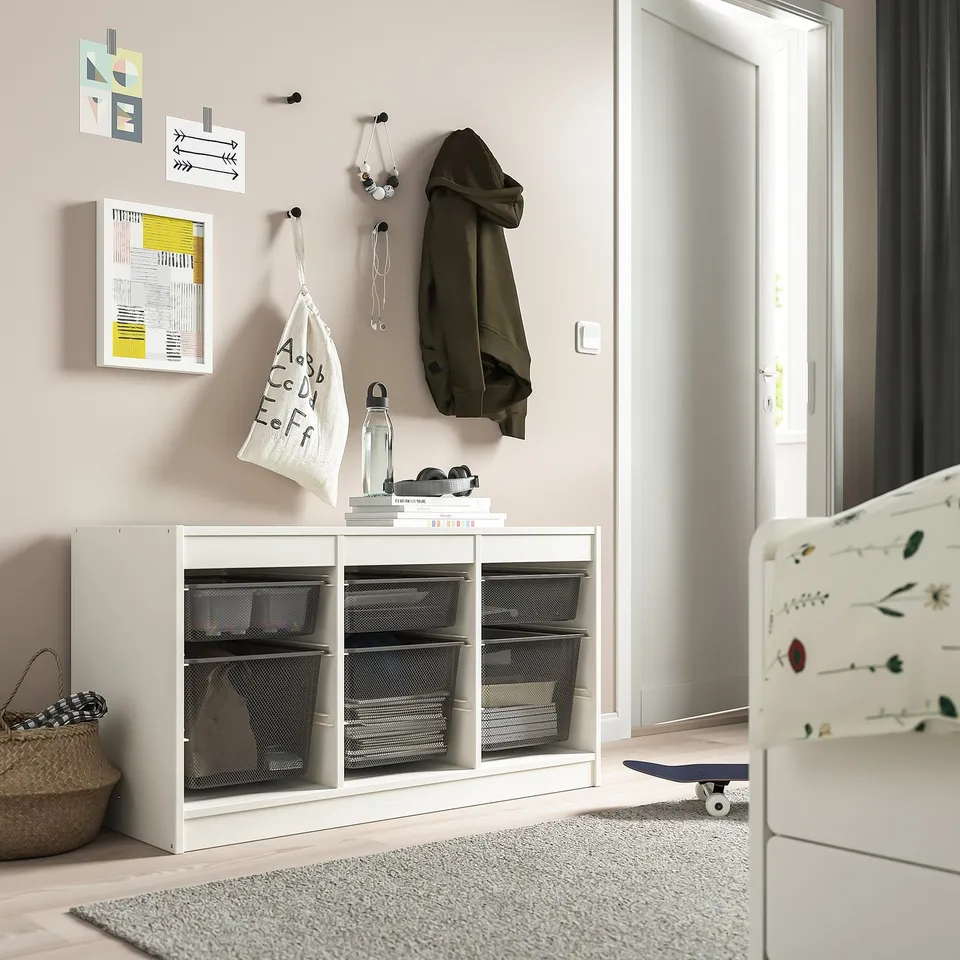 Modern storage unit, TROFAST, white, mesh boxes. Holds books, bottles, includes hooks and coat. Smaller than wall, larger than floor basket.