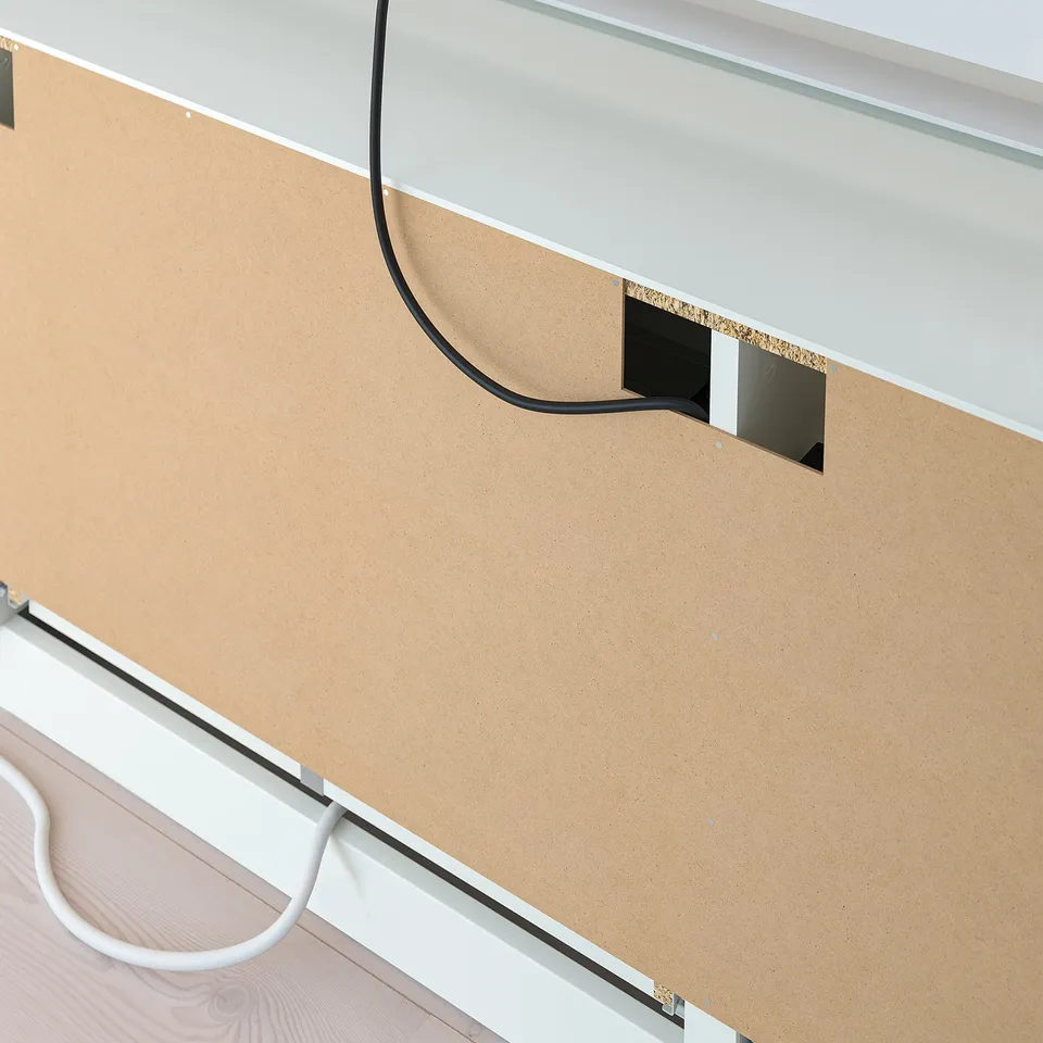 Corkboard with black panel and cord, part of a tv bench setup.
