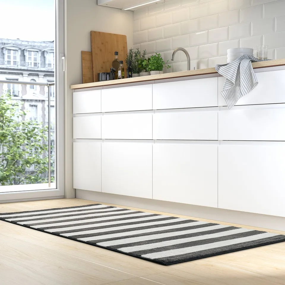 Black & white striped ELSYSTEM rug in minimalist kitchen, under sink, recycled polyester.