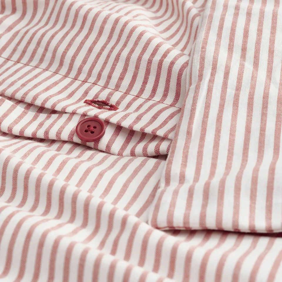 Close-up of red and white striped shirt button. Recycled cotton.