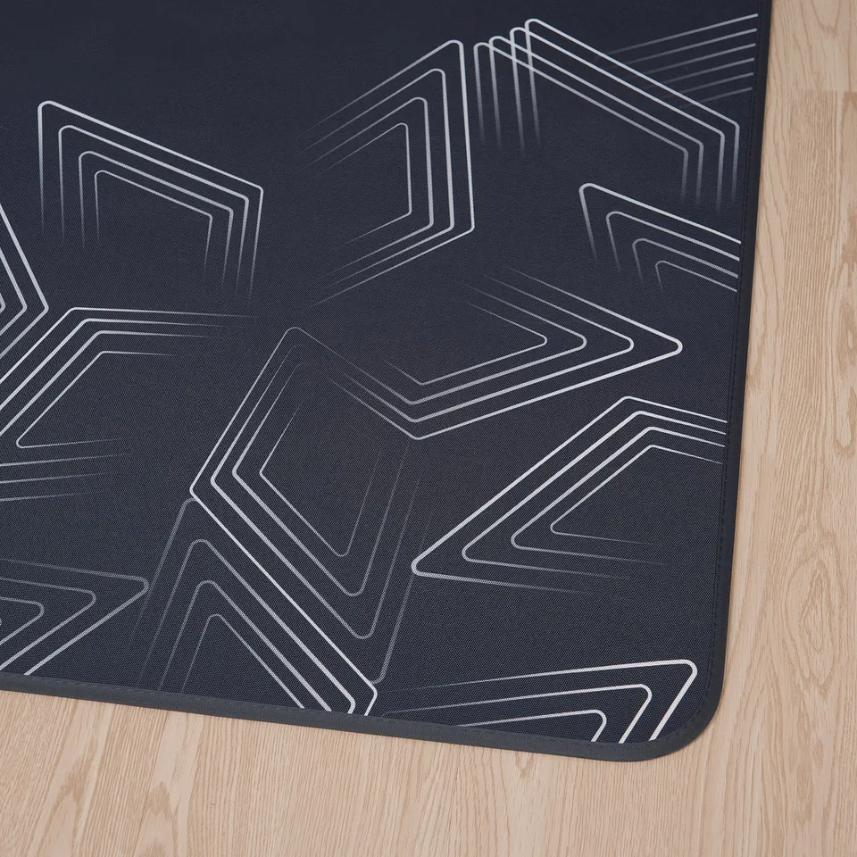 Black modern geometric rug on wood floor.