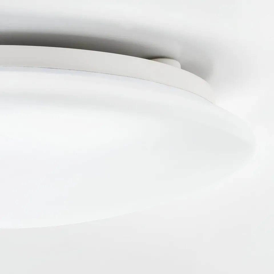 Modern ceiling light fixture with smooth white curves, perfectly suited for a bathroom setting.