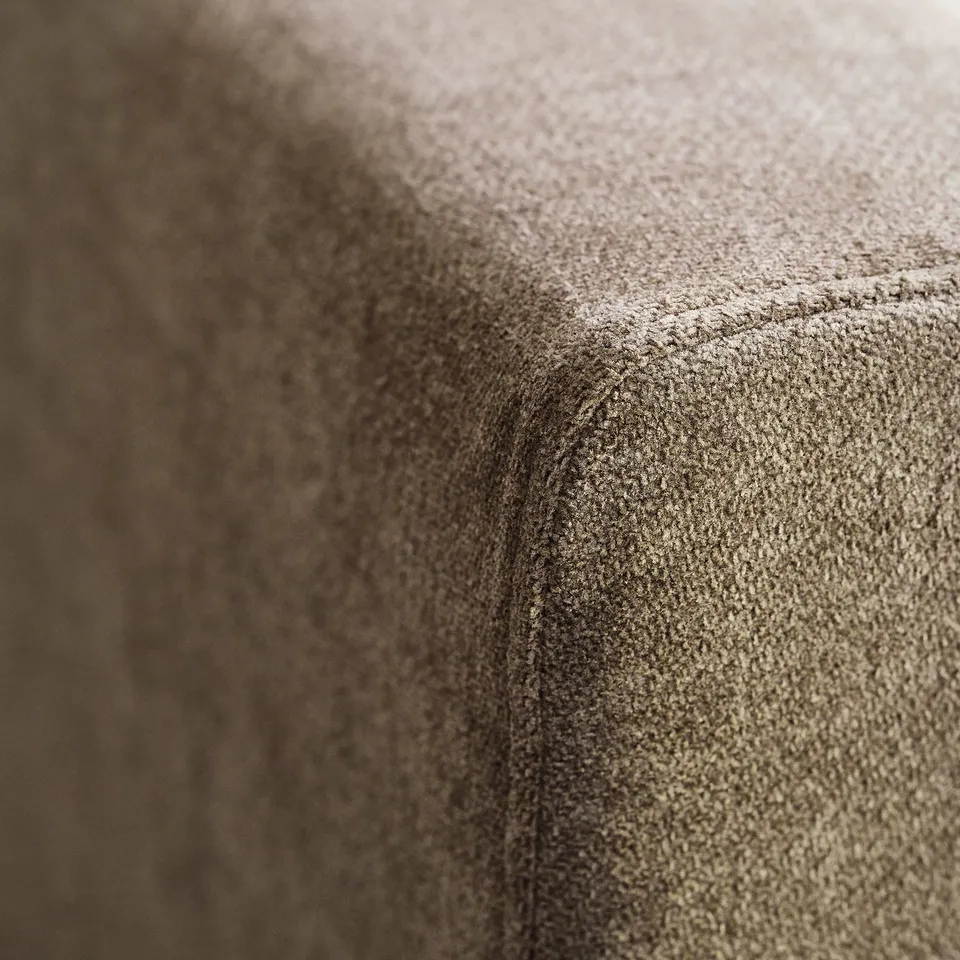 Close-up: plush, textured fabric sofa; soft, inviting texture; stitching shows quality craftsmanship.