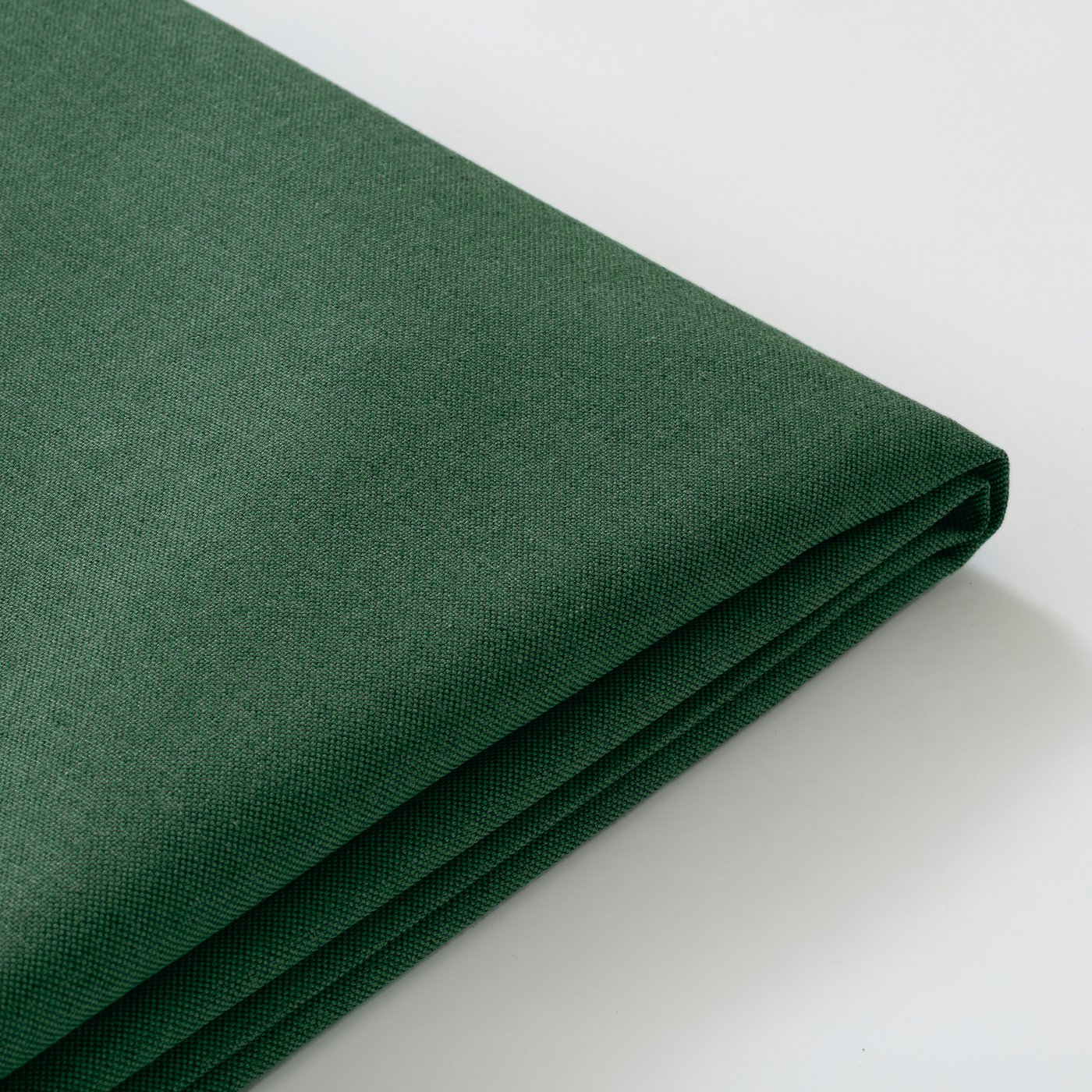 Dark green fabric, neatly folded, showcasing texture and quality. Ideal for sofa cover, appears durable and well-finished.