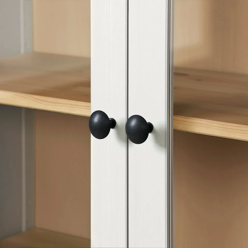 Wooden cabinet with black knobs, two shelves, sturdy, well-crafted.