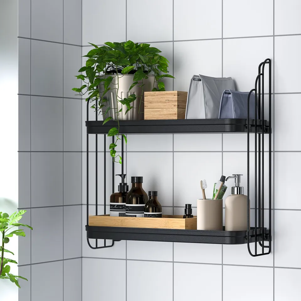 Black metal wall shelf holds plants, bathroom essentials, and storage bags in bathroom.