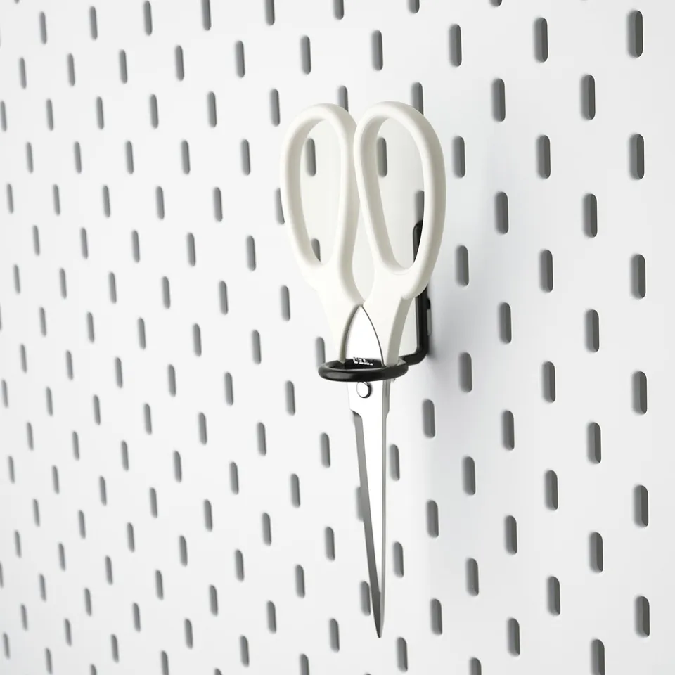 White scissors hang on black SKÅDIS pegboard for storage.