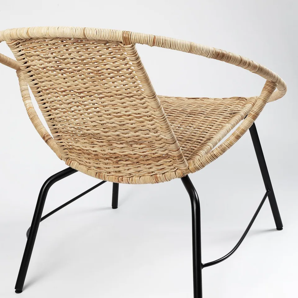 ORRESLÄTT armchair: durable woven rattan on black metal legs, elegant & sturdy design.