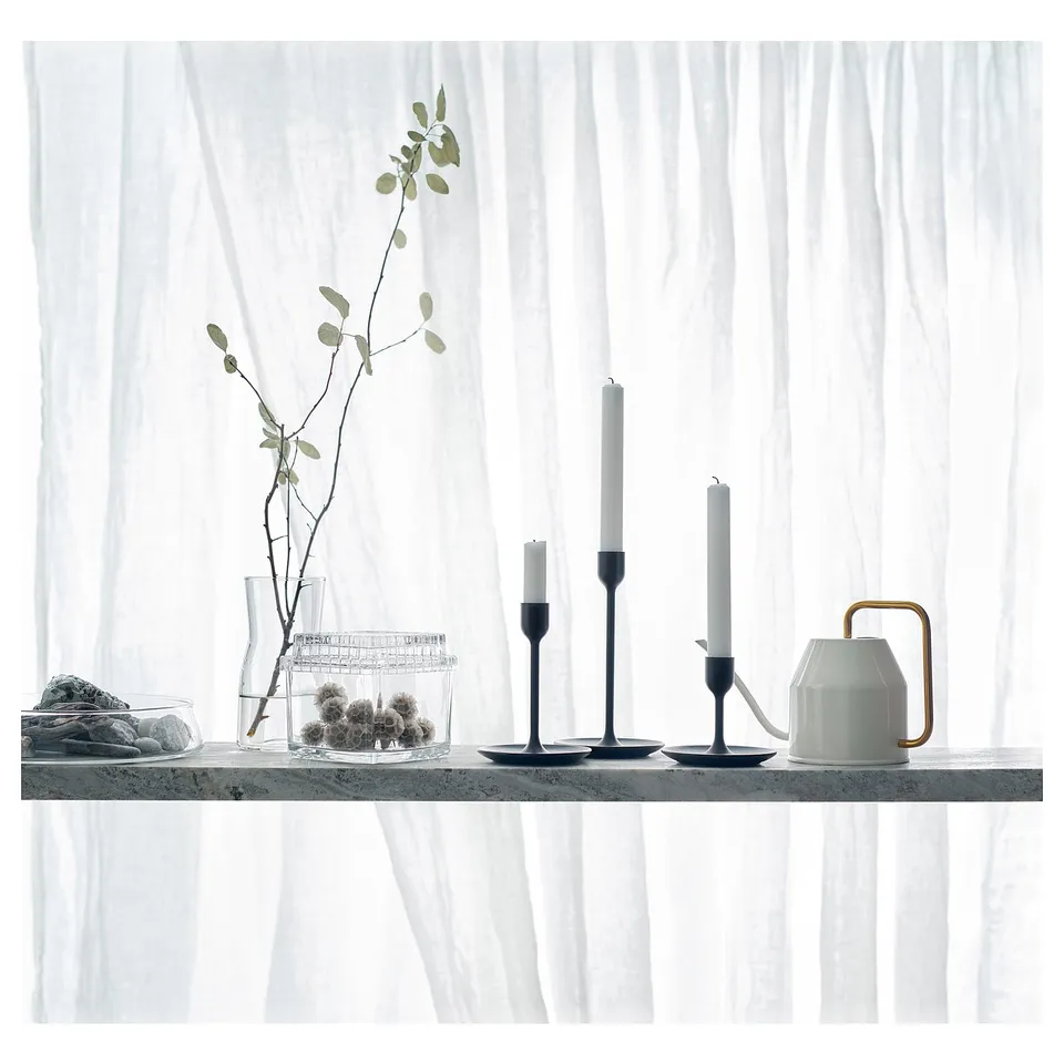 Minimalist window shelf with VATTENKRASSE white watering can, rock bowl, candle holders, and leafy vase.