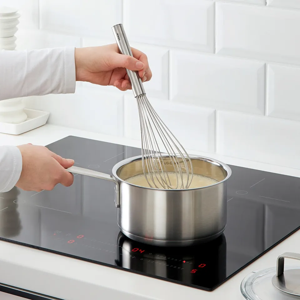 Whisking cream on modern stove with KONCIS whisk.