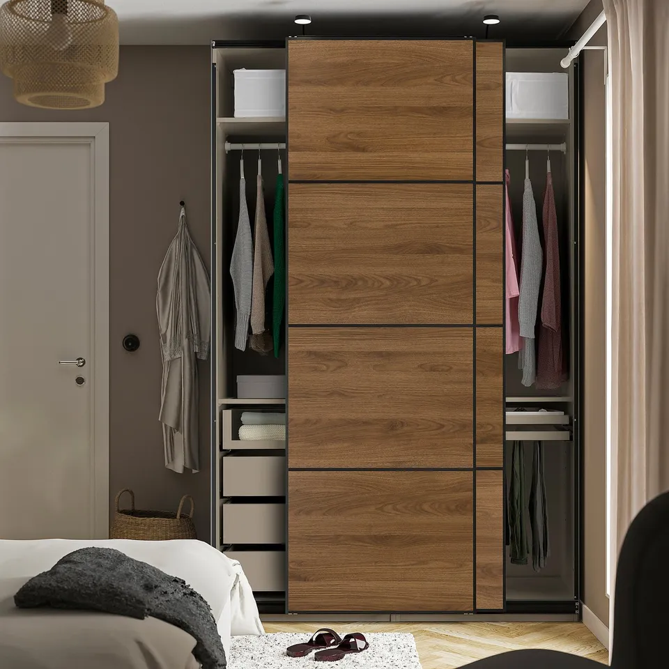 Bedroom with wooden sliding door wardrobe, hanging clothes, shelves, and drawers.