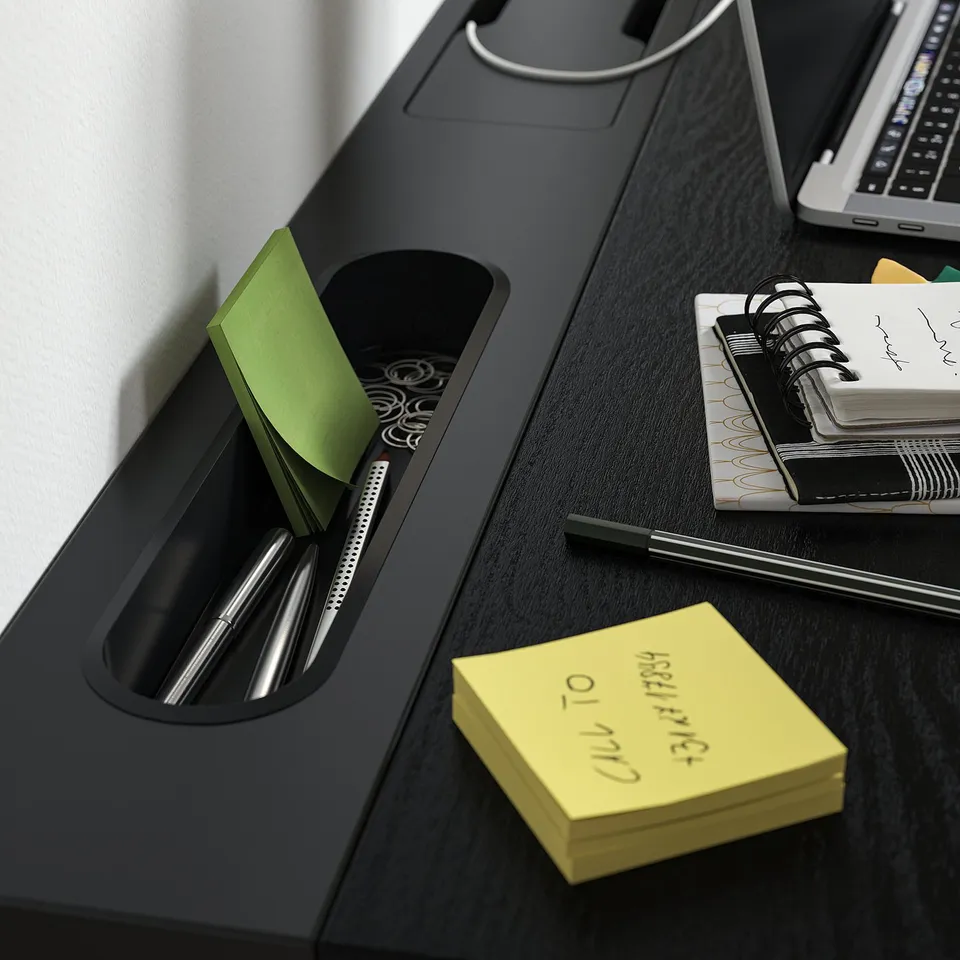 Desk with pen, sticky notes, and notebook. Clever compartments and a cable management tray.