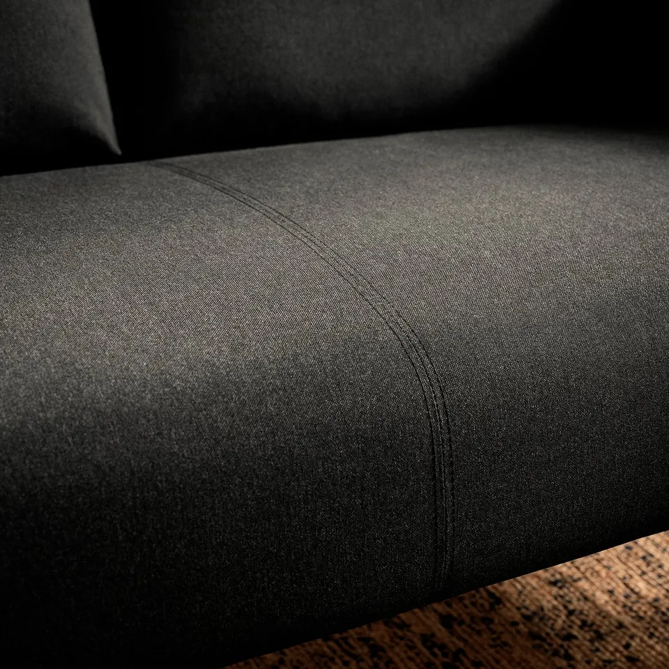Close-up of dark, textured sofa cushions. Expert stitching, quality fabric. Inviting comfort.