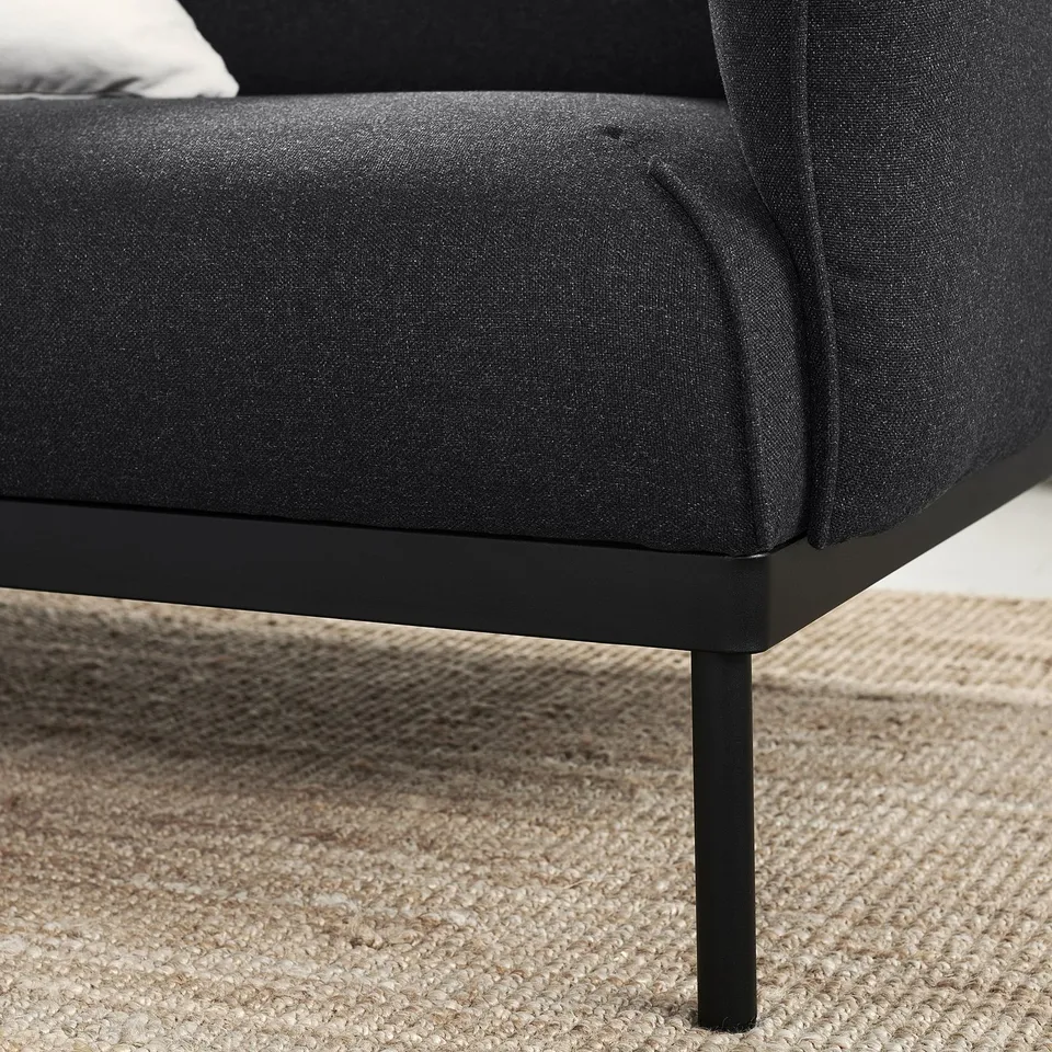 Modern black fabric sofa, sleek metal legs, cosy cushion.