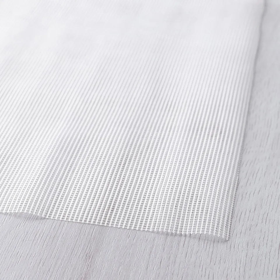 White textured anti-slip mat close-up, showing detailed grid pattern and flexible material.