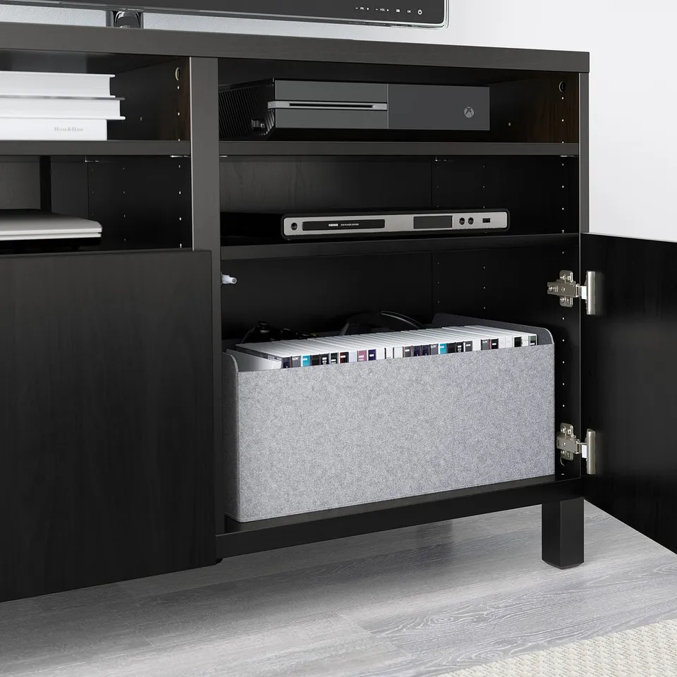 Black BESTÅ tv unit, open doors reveal organised electronics and storage.