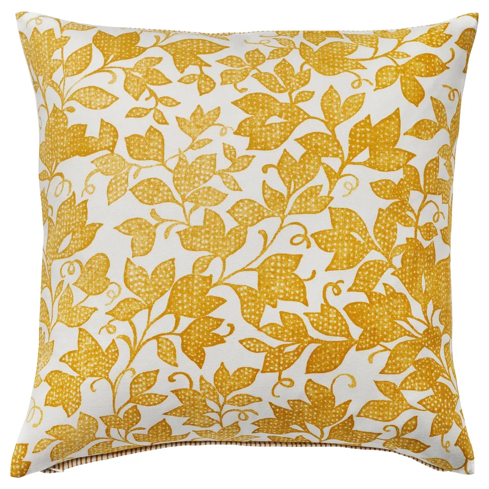 Mustard-yellow patterned cushion, white background, leafy design, square shape, zip at bottom.