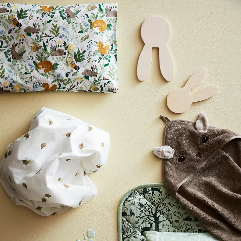 TROLLDOM baby items: quilted blanket & deer pillow.