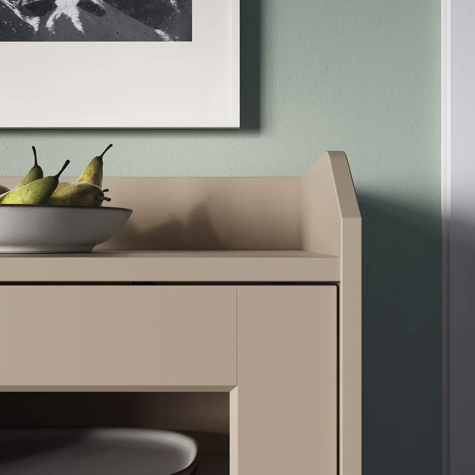 Kitchen counter with beige HAUGA cabinet, green fruits in bowl, green wall.