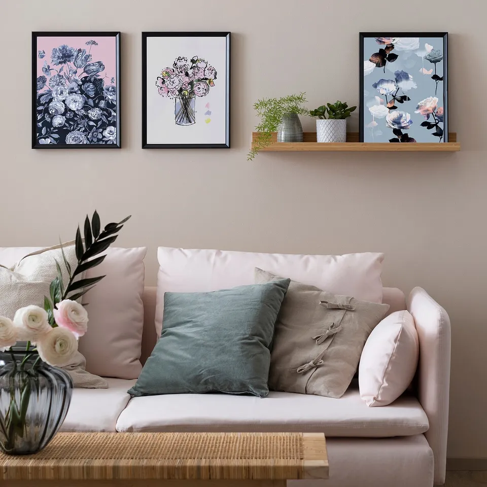 Living room with KNOPPÄNG sofa, pastel pillows, floral art, plants.