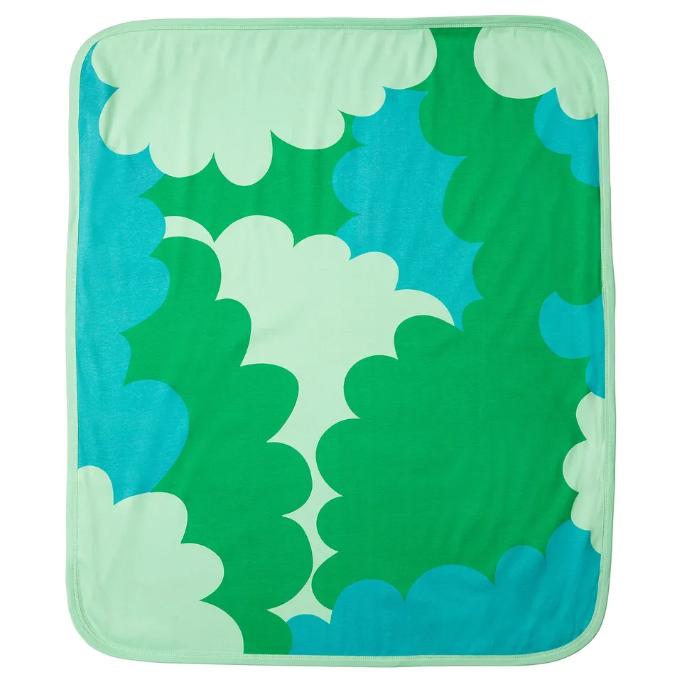 A GRÖNFINK baby blanket in green, blue, and light mint colours, showcasing a stylized leaf design on a soft cotton material.