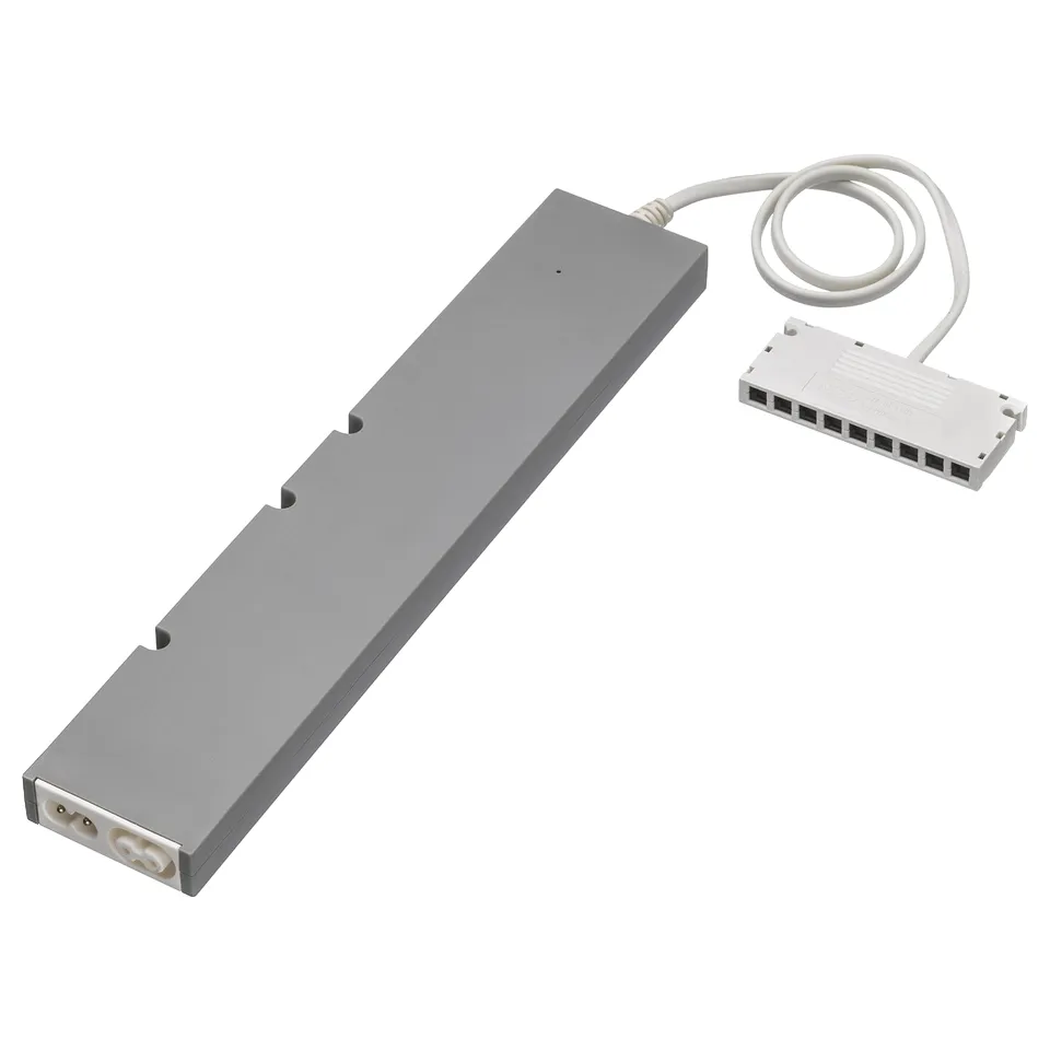 A grey IKEA TRÅDFRI lighting driver, rectangular, made of polycarbonate plastic, with a white cord and connector.